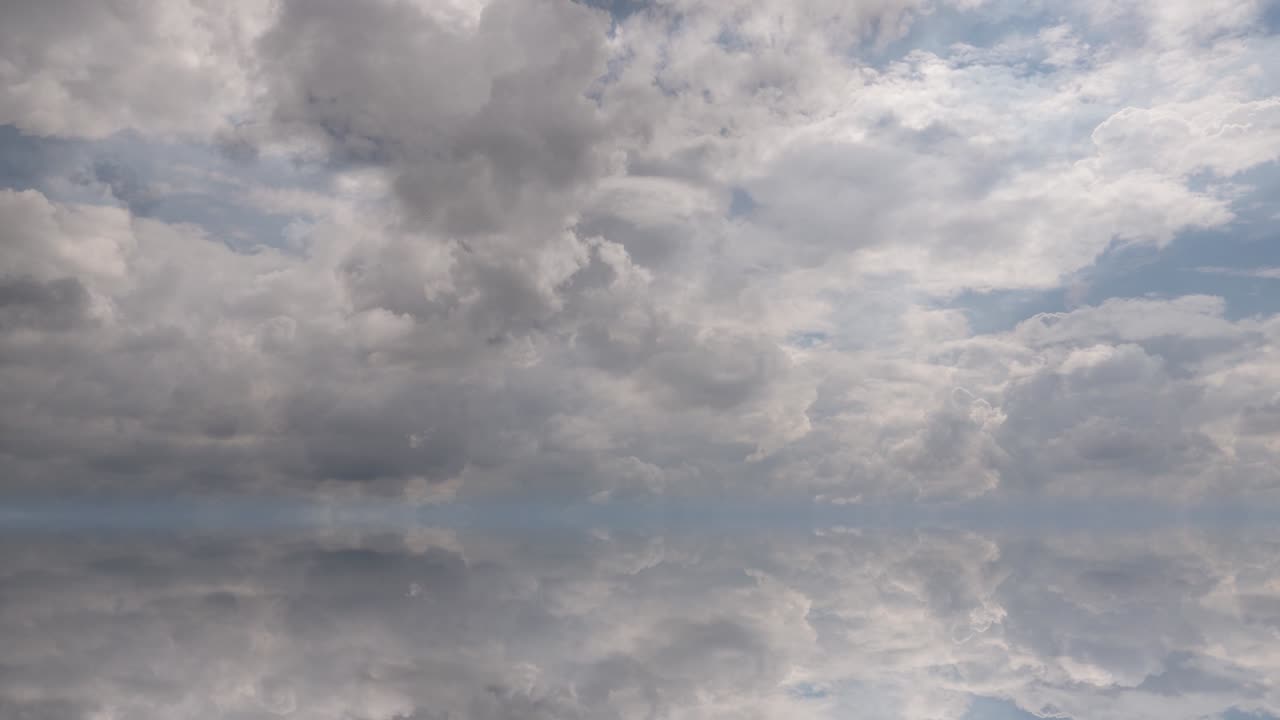 futuristic background consisting of Time lapse clip of white fluffy clouds over blue sky and their reflection, video loop