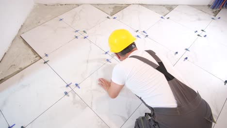 a man installs ceramic tiles in a new apartment
