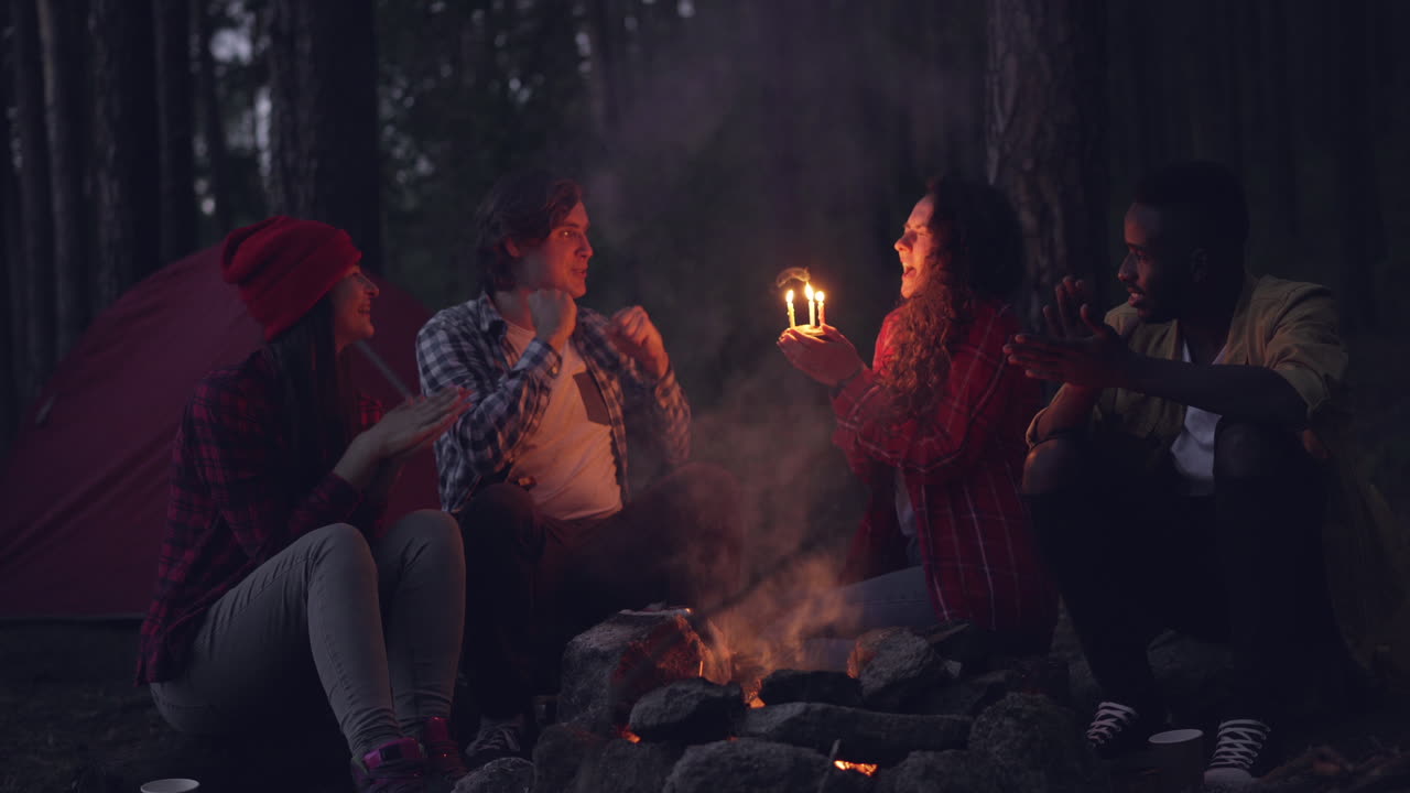 Friends celebrating by the campfire at night