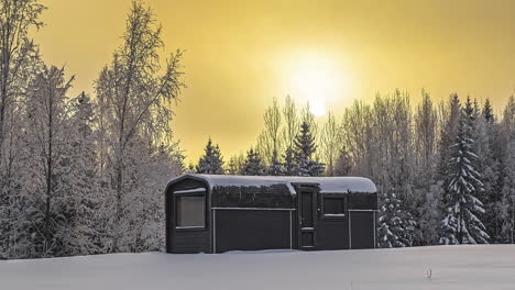 Small-cabin-next-to-woods-in-pure-white-snowy-landscape