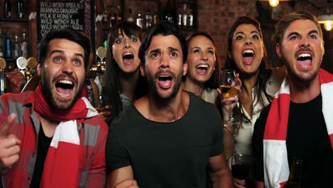 gruppe von freunden, die in einer bar fernsehen