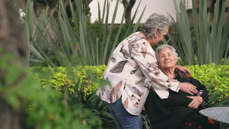 senior woman kissing sister on head