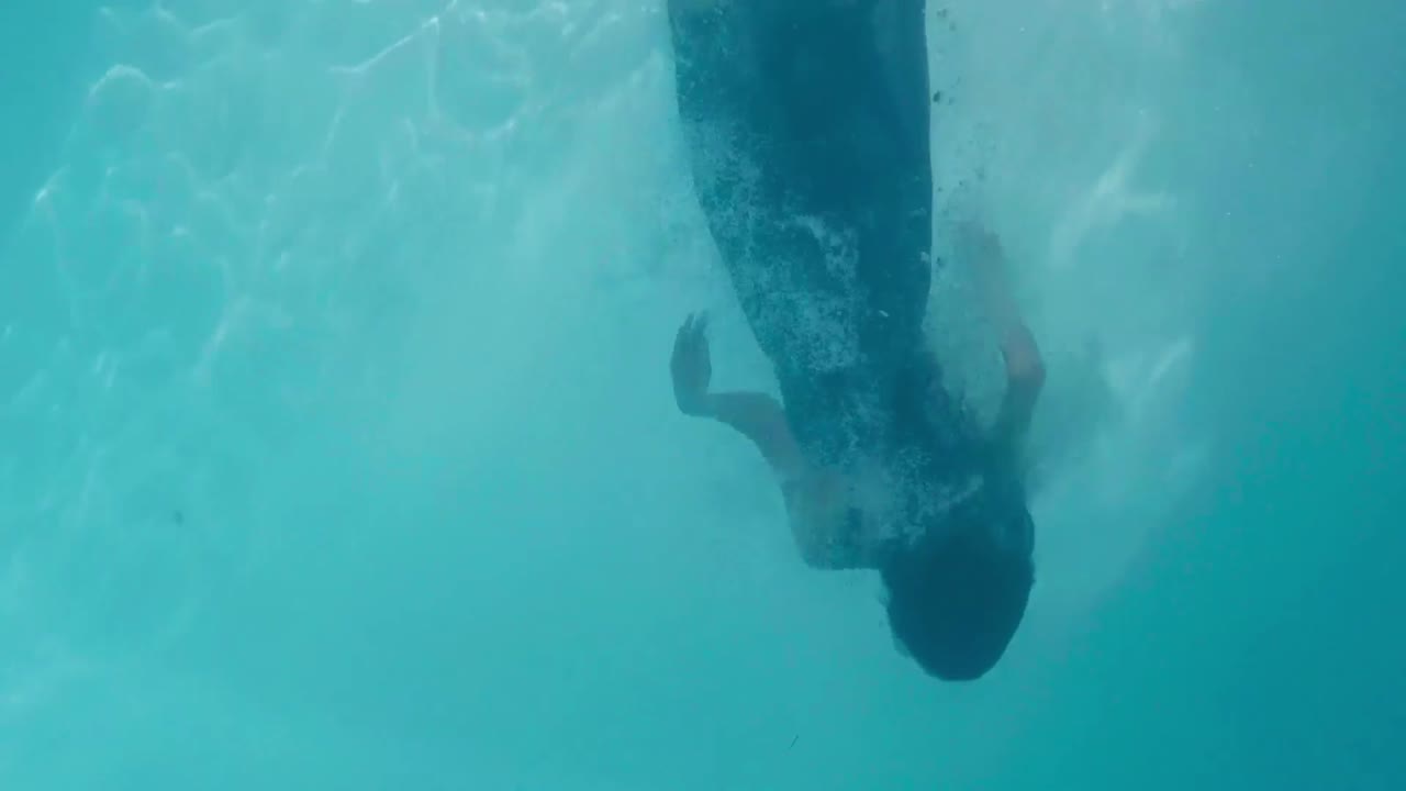 una mujer hermosa buceando en la piscina.