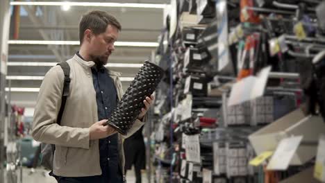 hombre comprando un rodillo de masaje en una tienda de artículos deportivos