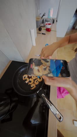 person recording shrimp being cooked with a smartphone