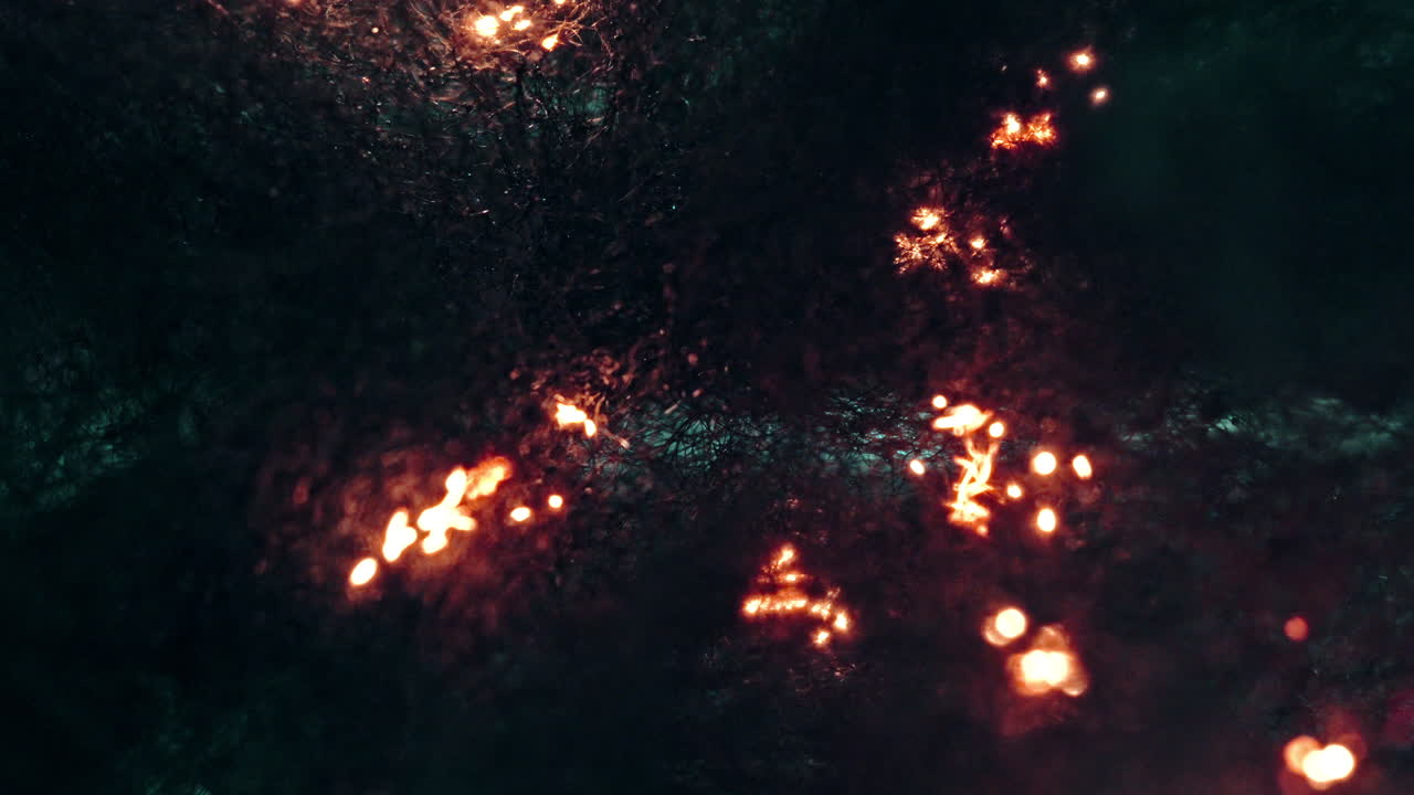 Burning flames in macro shot, glowing fire sparks, intense fiery glow on dark backdrop