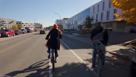 woman cycling on city street in autumn