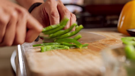 Green-pepper,-wood-board-and-knife-in-hands