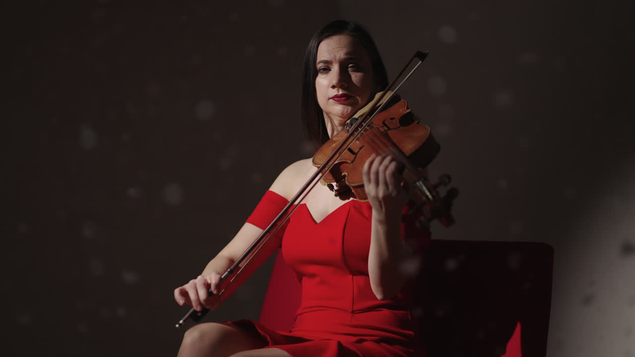 mujer tocando el violín en vestido rojo