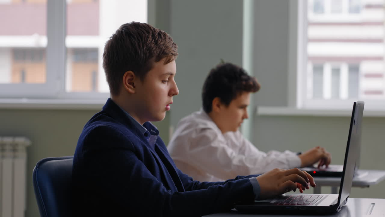 Studenti che lavorano con i portatili in classe