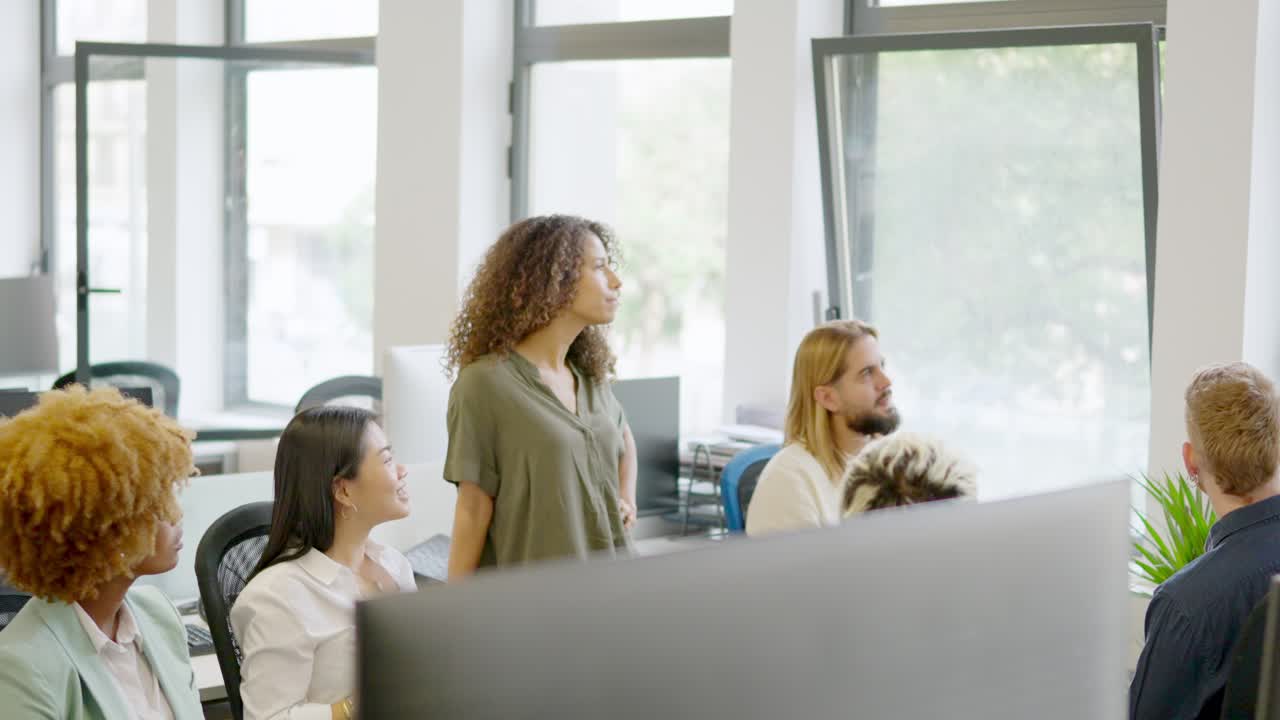 Multi-ethnic coworkers listening to the manager in a business meeting
