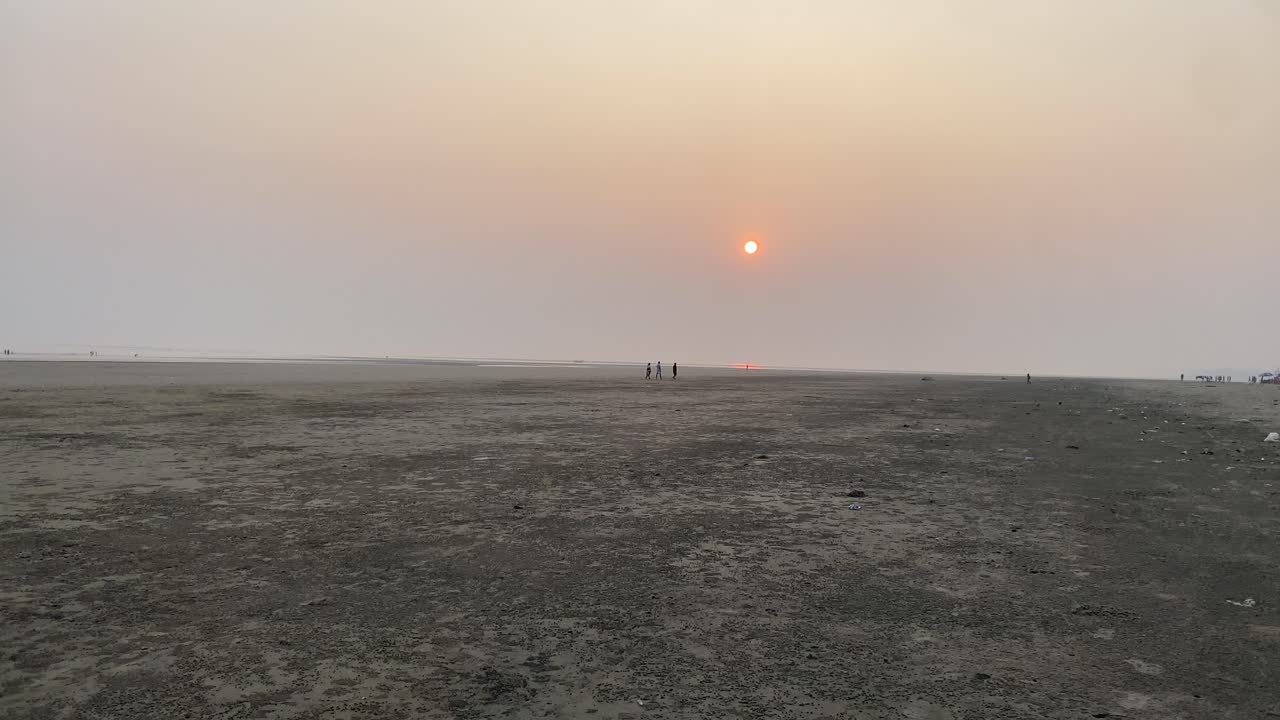 Slow motion shot of sunset view in the beach side of Kolkata with people at a distant