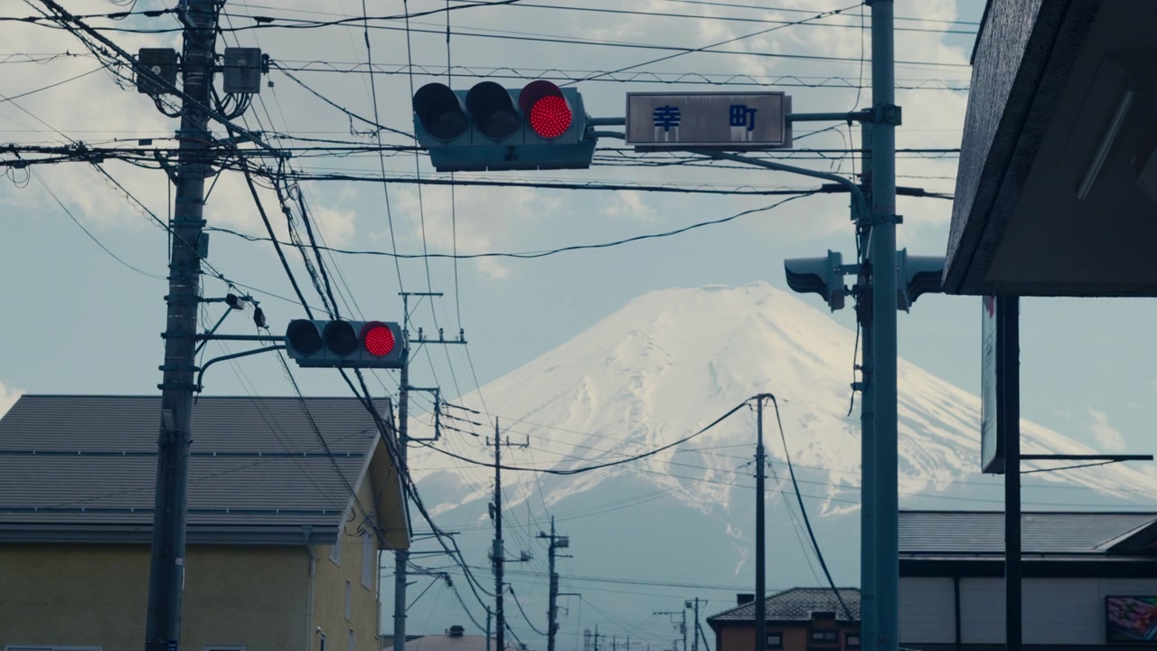 Strada residenziale a Kawaguchiko con il monte Fuji sotto un cielo blu.