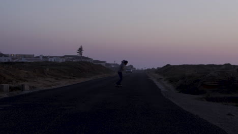 skateboarder on a coastal road at sunset