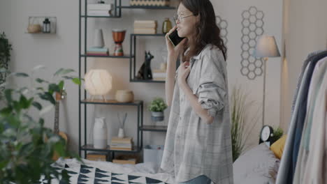 young woman talking on phone in bedroom