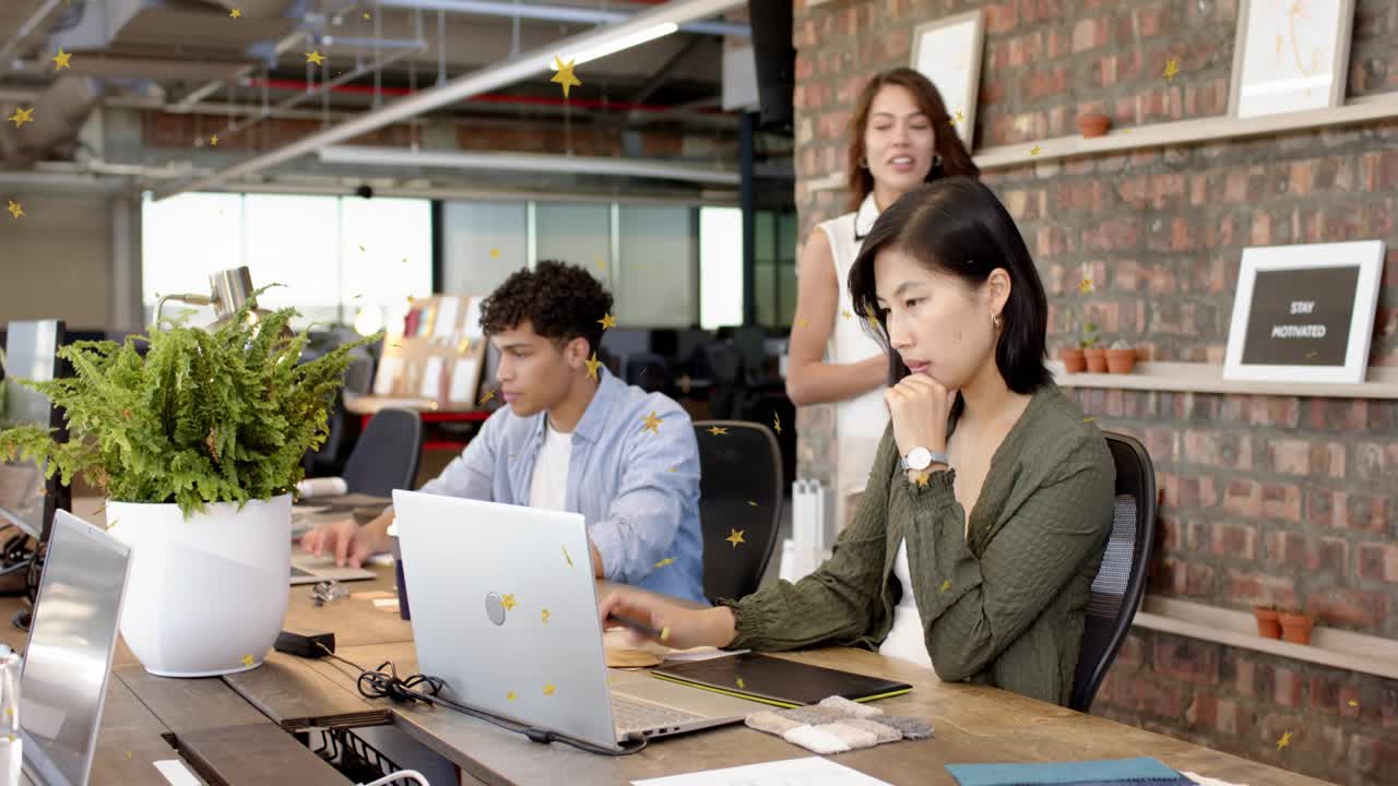 Designer tapping pen and launching animated UI to review design in open office as colleague nears