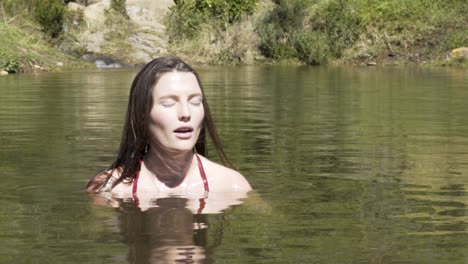 toma en cámara lenta de una chica que se sumerge bajo el agua en una presa