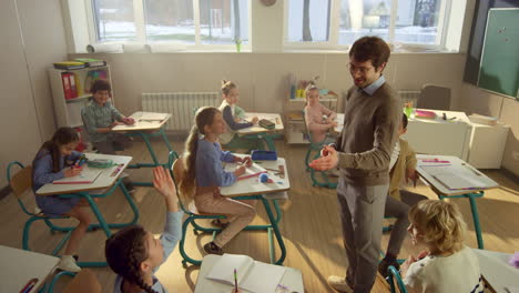 teacher asking questions to students in class. schoolchildren raising hands