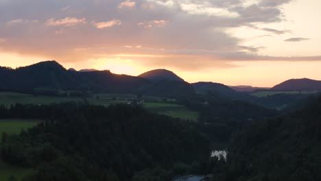 sunset aerial in beautiful nature with hilly landscape and orange sky