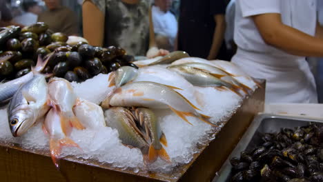 fresh fish and seafood on ice at a market stall