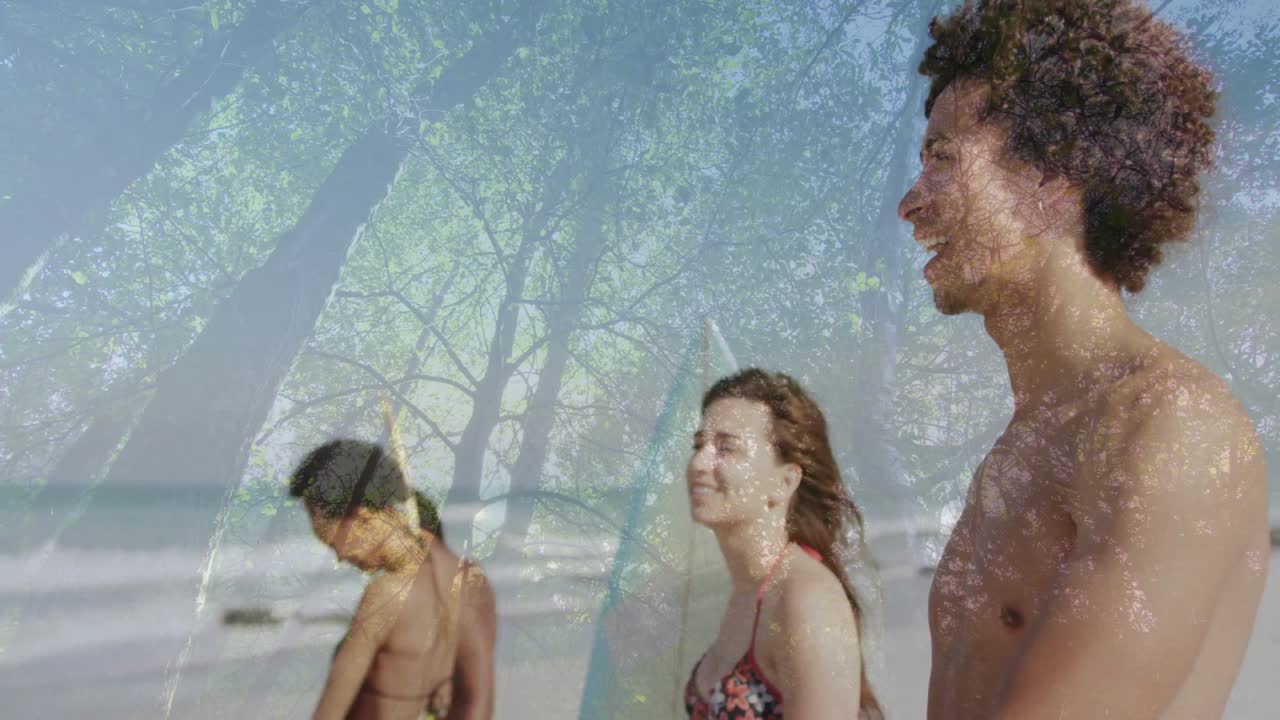 Surfista che alza il braccio indicando le onde negli sport da spiaggia, con amici che regolano le tavole preparandosi per il surf.