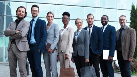 Group-of-multiethnic-business-people-in-stylish-clothes-smiling-and-looking-at-camera-in-the-street