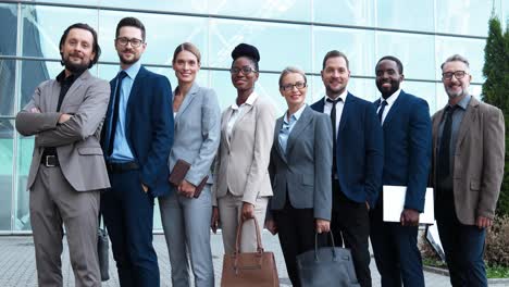 grupo de empresarios multiétnicos con ropa elegante sonriendo y mirando la cámara en la calle