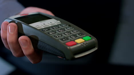 Pos-terminal-payment.-Human-hand-swipe-credit-card-in-payment-terminal