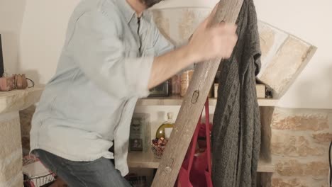 a man going up and down an old ladder at home