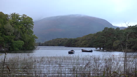 two boats floating on calm muckross lake in county kerry, ireland