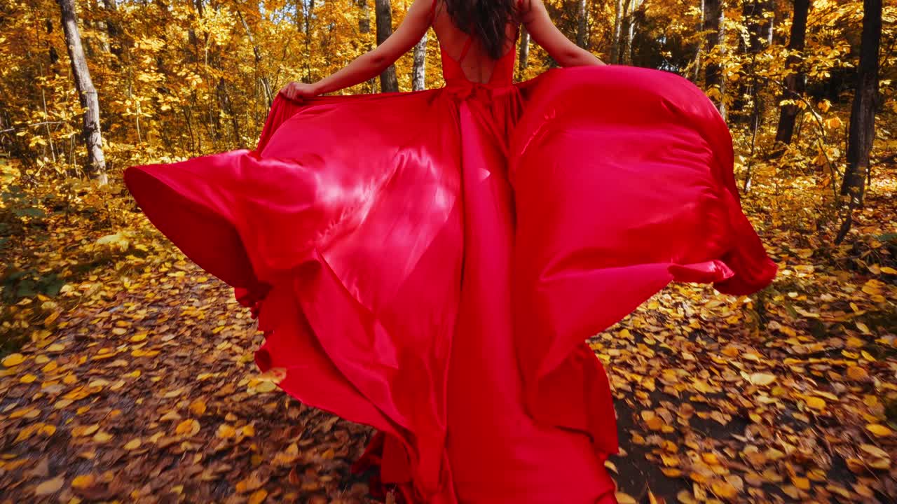 A Majestic Journey Through Autumn: A Woman in a Flowing Red Dress Captivates Nature's Palette Amidst Vibrant Golden Leaves and Serene Forest Pathways