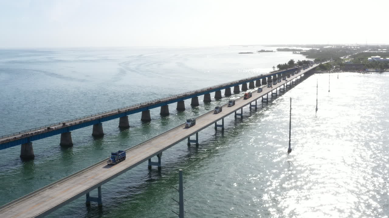 Dump trucks driving down the 7 mile bridge in the Florida Keys