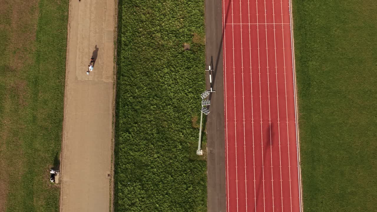 Aerial view looking down over sporting preparation on red athletics running track at Parliament hill