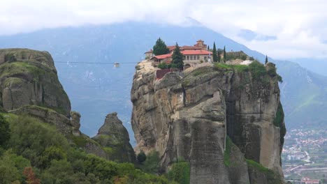 a cable car moves across a chasm to a monastery in meteroa greece 2