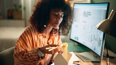 woman eating noodles at her desk
