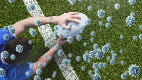 animación de células del virus covid 19 sobre un jugador de rugby caucásico con una pelota