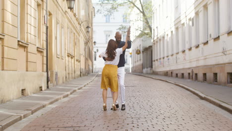 interracial couple dancing bachata in the old town street