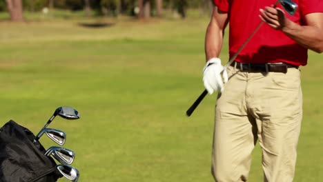 male golfer removing golf club from golf bag