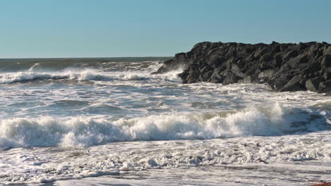 breakwater crashes against jetty in gold beach, oregon coast