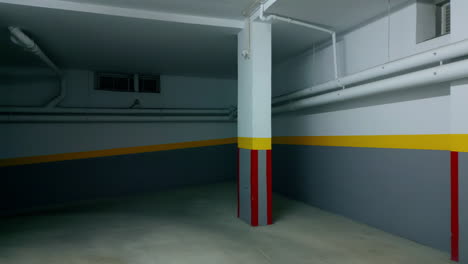 dark empty building corridor painted in gray yellow red colours with collouns.