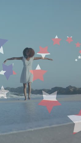 Animación-De-Estrellas-Y-Bandera-Americana-Sobre-Una-Mujer-Afroamericana-Levantando-La-Mano-En-La-Playa