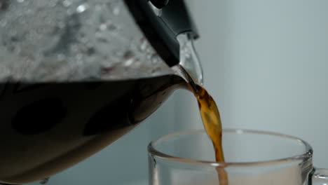 pouring coffee from a pot into a glass