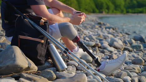 man with prosthetic leg hiking by a river