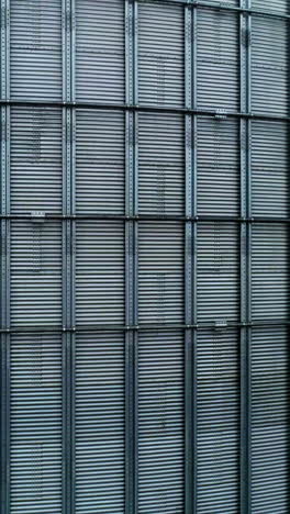 metal surface of huge elevator container. rising along the silver shell of granary tank up to the top. foggy sky backdrop. vertical video