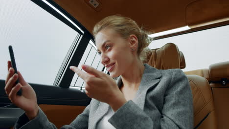 mujer en primer plano haciendo una llamada de video en el coche. mujer salida celebrando la victoria en el coche