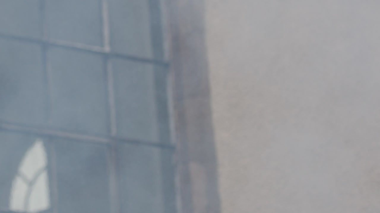 Humo denso sale por la ventana de un edificio, lo que sugiere un posible incendio o situación peligrosa, luz del día