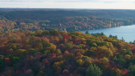 dorset lookout tower surrounded by colorful autumn forest in ontario, canada, aerial view