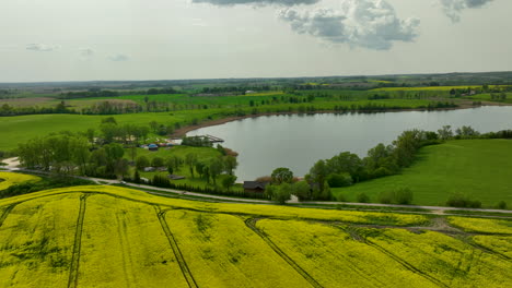 a wide view of a countryside landscape featuring a large lake surrounded by green fields and trees