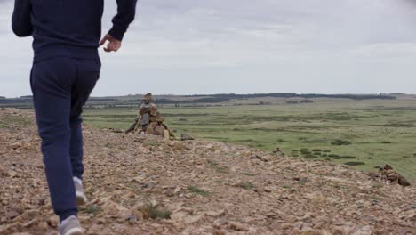 man running through scenic mountain terrain