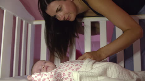 Mother-At-Home-With-Sleeping-Newborn-Baby-In-Nursery-Cot